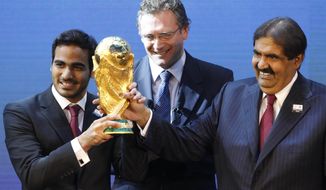 Mohamed bin Hamad Al-Thani, left, Chairman of the 2022 bid committee, and Sheikh Hamad bin Khalifa Al-Thani, Emir of Qatar, hold the World Cup trophy in front of FIFA Secretary General Jerome Valcke after the announcement that Qatar will host the 2022 soccer World Cup, on Dec. 2, 2010, in Zurich, Switzerland. Qatar has for years employed a former CIA officer to help spy on soccer officials as part of an aggressive effort to win and hold on to the 2022 World Cup tournament, an investigation by The Associated Press has found. (AP Photo/Anja Niedringhaus, File) **FILE**