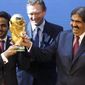 Mohamed bin Hamad Al-Thani, left, Chairman of the 2022 bid committee, and Sheikh Hamad bin Khalifa Al-Thani, Emir of Qatar, hold the World Cup trophy in front of FIFA Secretary General Jerome Valcke after the announcement that Qatar will host the 2022 soccer World Cup, on Dec. 2, 2010, in Zurich, Switzerland. Qatar has for years employed a former CIA officer to help spy on soccer officials as part of an aggressive effort to win and hold on to the 2022 World Cup tournament, an investigation by The Associated Press has found. (AP Photo/Anja Niedringhaus, File) **FILE**
