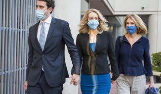 Elizabeth Holmes, center, walks into federal court in San Jose, Calif., Monday, Nov. 22, 2021. Holmes is accused of duping elite financial backers, customers and patients into believing that her startup was about to revolutionize medicine. (AP Photo/Nic Coury)