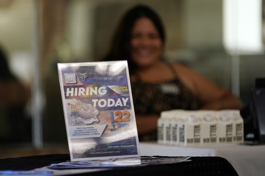 A hiring sign is placed at a booth for prospective employers during a job fair Wednesday, Sept. 22, 2021, in the West Hollywood section of Los Angeles. (AP Photo/Marcio Jose Sanchez, File)