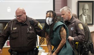 Darrell Brooks Jr., center, is escorted out of the courtroom after making his initial appearance, Tuesday, Nov. 23, 2021, in Waukesha County Court in Waukesha, Wis. Prosecutors in Wisconsin have charged Brooks with intentional homicide in the deaths of at least five people who were killed when an SUV was driven into a Christmas parade. (Mark Hoffman/Milwaukee Journal-Sentinel via AP, Pool)