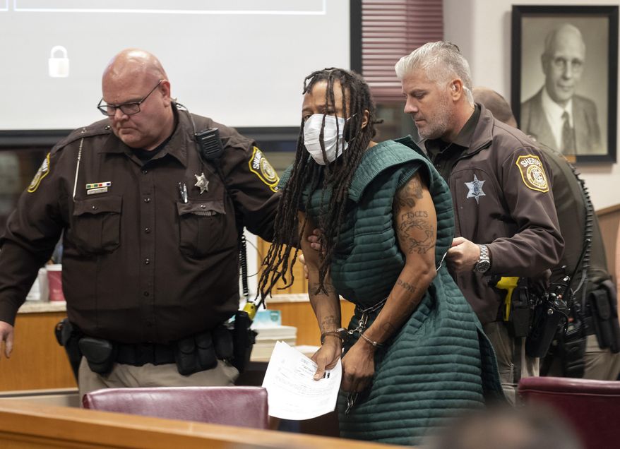 Darrell Brooks Jr., center, is escorted out of the courtroom after making his initial appearance, Tuesday, Nov. 23, 2021, in Waukesha County Court in Waukesha, Wis. Prosecutors in Wisconsin have charged Brooks with intentional homicide in the deaths of at least five people who were killed when an SUV was driven into a Christmas parade. (Mark Hoffman/Milwaukee Journal-Sentinel via AP, Pool)