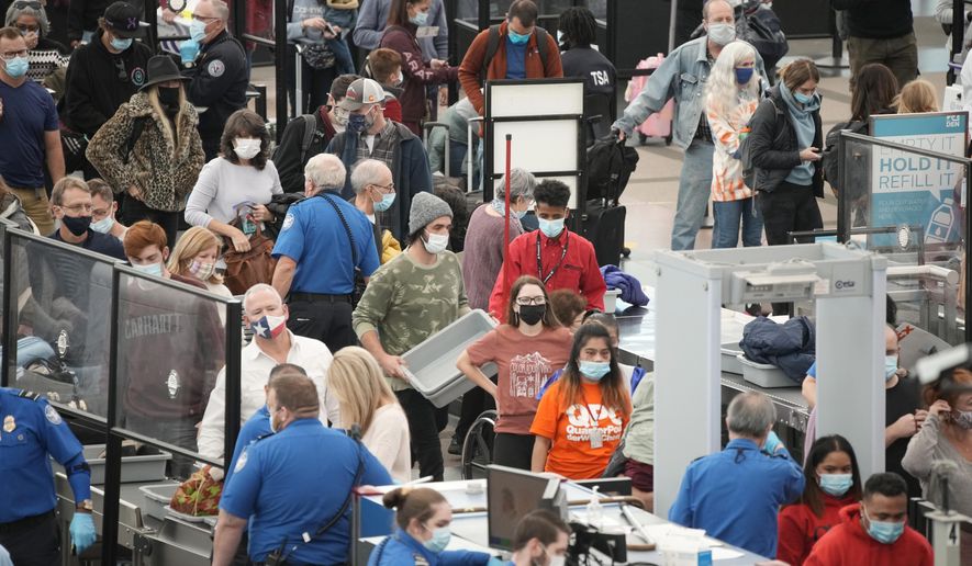 Travelers queue up at the south security checkpoint as traffic increases with the approach of the Thanksgiving Day holiday Tuesday, Nov. 23, 2021, at Denver International Airport in Denver. (AP Photo/David Zalubowski)