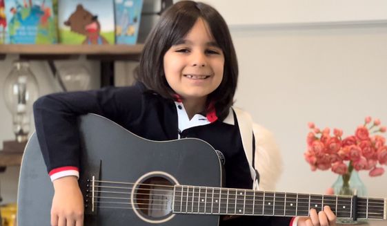 Aiden Adams, 7, of Bethesda, Maryland, has become a social media influencer with his songs, poems and books urging people to make the world a better place (Photo by Neal Adams)