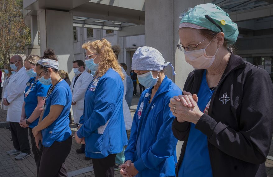 A health care worker prays outside Saint Francis Hospital, Thursday, May 7, 2020, in Hartford, Conn. A federal judge in Missouri on Monday temporarily blocked the Biden administration&#x27;s COVID-19 vaccine mandate for health care workers in 10 states. (AP Photo/Mark Lennihan, File)