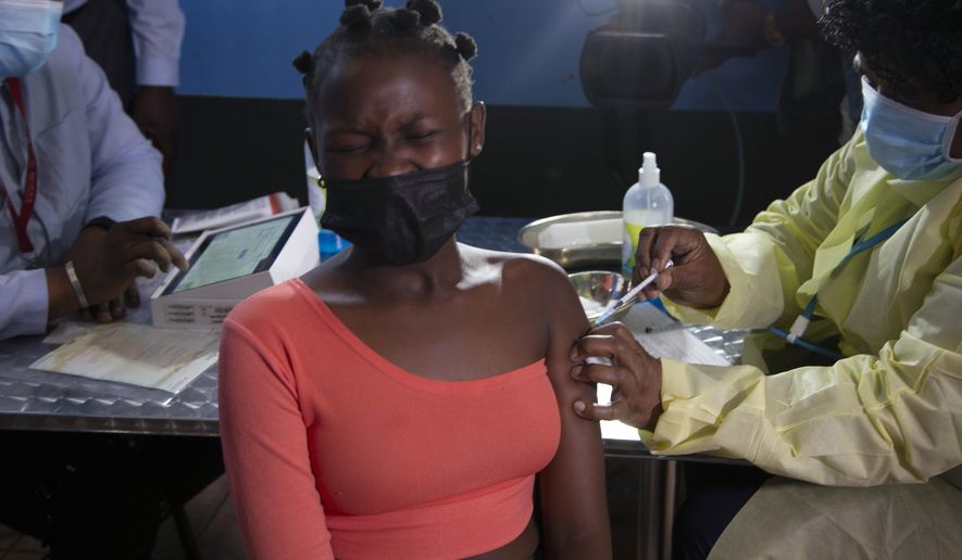 FILE - A  young woman reacts as she receives a Pfizer jab against COVID-19, in Diepsloot Township near Johannesburg Thursday, Oct. 21, 2021. A new COVID-19 variant has been detected in South Africa that scientists say is a concern because of its high number of mutations and rapid spread among young people in Gauteng, the country&#x27;s most populous province, Minister of Health Joe Phaahla announced Thursday, Nov. 25, 2021. (AP Photo/Denis Farrell, File)