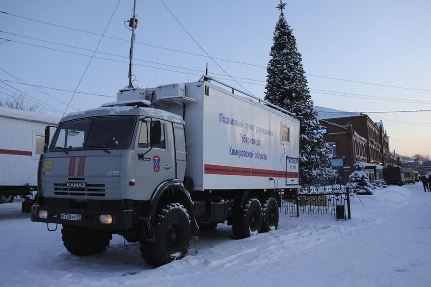 A Russian Emergency Ministry truck is parked at the Listvyazhnaya mine, right, near Belovo, in the Kemerovo region of southwestern Siberia, Russia, Friday, Nov. 26, 2021. A devastating explosion in the Siberian coal mine Thursday left dozens of miners and rescuers dead about 250 meters (820 feet) underground, Russian officials said.(AP Photo/Sergei Gavrilenko)