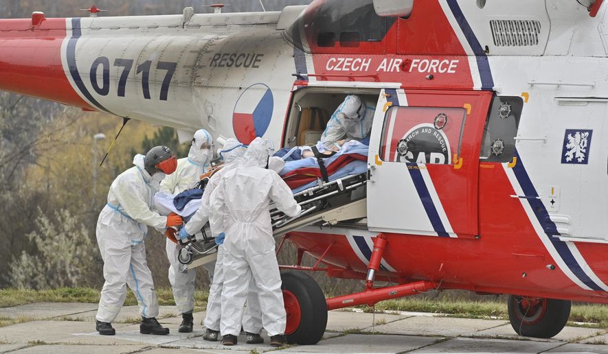Health workers at the Motol University Hospital take out of army helicopter one of the patients with COVID-19, who was transported to Prague from a hospital in Brno, Czech Republic, Thursday, Nov. 25, 2021. COVID spread reaches another record in Czech Republic, with 27,717 new confirmed COVID cases on Thursday, another daily maximum since the start of the epidemic. (Vit Simanek / CTK via AP)