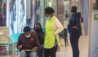 People wait to get vaccinated at a shopping mall, in Johannesburg, South Africa, Friday Nov. 26, 2021. Advisers to the World Health Organization are holding a special session Friday to flesh out information about a worrying new variant of the coronavirus that has emerged in South Africa, though its impact on COVID-19 vaccines may not be known for weeks. (AP Photo/Denis Farrell)