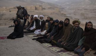 Taliban fighters and Afghan men pray in Kamar Kalagh village near Herat, Afghanistan, Saturday , Nov. 27, 2021. (AP Photo/Petros Giannakouris)