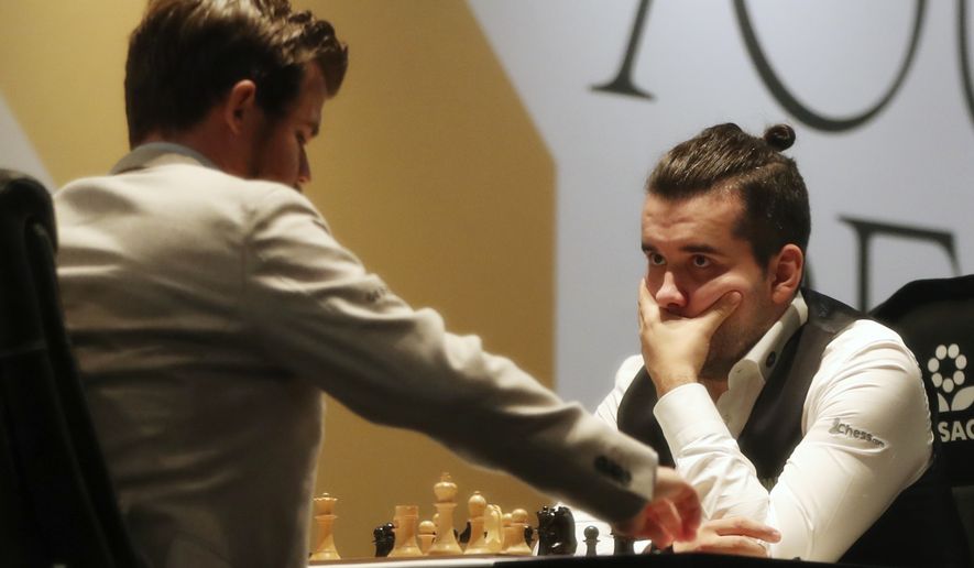 Norway&#39;s World Chess Champion Magnus Carlsen, left, competes with Ian Nepomniachtchi of Russia, during their game two of the FIDE World Championship at the Dubai Expo, in Dubai, United Arab Emirates, Saturday, Nov. 27, 2021. (AP Photo/Kamran Jebreili)