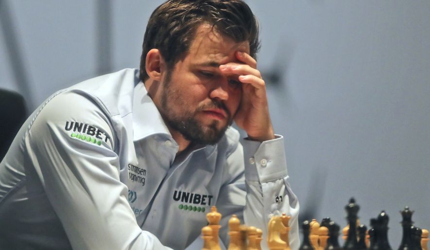 Norway&#x27;s World Chess Champion Magnus Carlsen, takes a moment against Ian Nepomniachtchi of Russia, during their game two of the FIDE World Championship at the Dubai Expo, in Dubai, United Arab Emirates, Saturday, Nov. 27, 2021. (AP Photo/Kamran Jebreili)