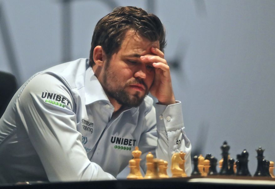 Norway&#39;s World Chess Champion Magnus Carlsen, takes a moment against Ian Nepomniachtchi of Russia, during their game two of the FIDE World Championship at the Dubai Expo, in Dubai, United Arab Emirates, Saturday, Nov. 27, 2021. (AP Photo/Kamran Jebreili)