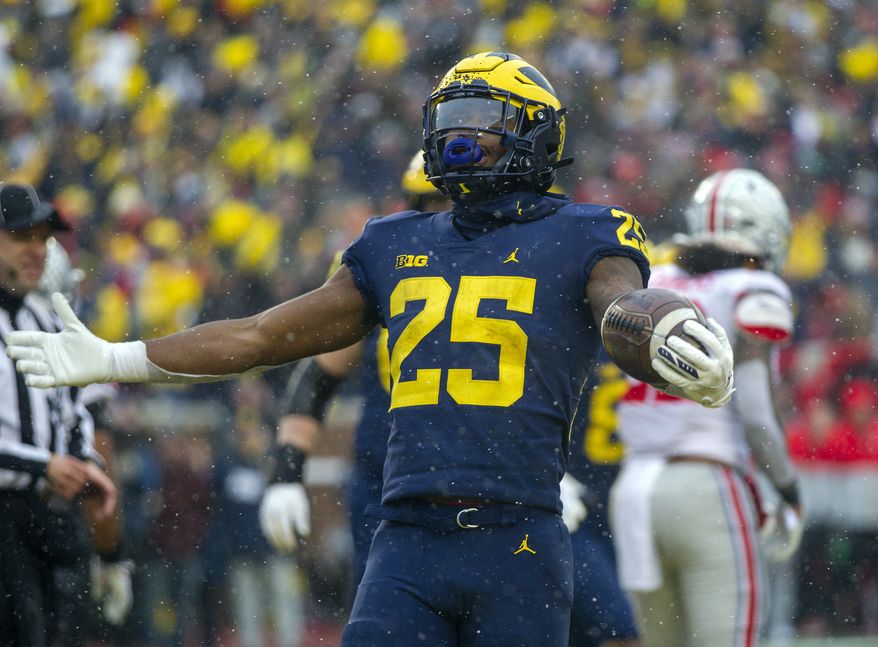 Michigan running back Hassan Haskins (25) celebrates a touchdown in the fourth quarter of an NCAA college football game against Ohio State in Ann Arbor, Mich., Saturday, Nov. 27, 2021. Michigan won 42-27. (AP Photo/Tony Ding) **FILE**