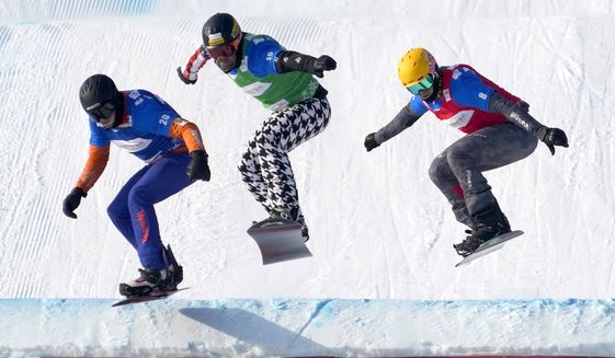 From left, Glenn de Blois of the Netherlands, Nick Baumgartner of the United States, and Jakob Dusek of Austria compete during a semifinal of men&#x27;s snowboard cross at the FIS Snowboard Cross World Cup, a test event for the 2022 Winter Olympics, at the Genting Resort Secret Garden in Zhangjiakou in northern China&#x27;s Hebei Province, Sunday, Nov. 28, 2021. (AP Photo/Mark Schiefelbein)