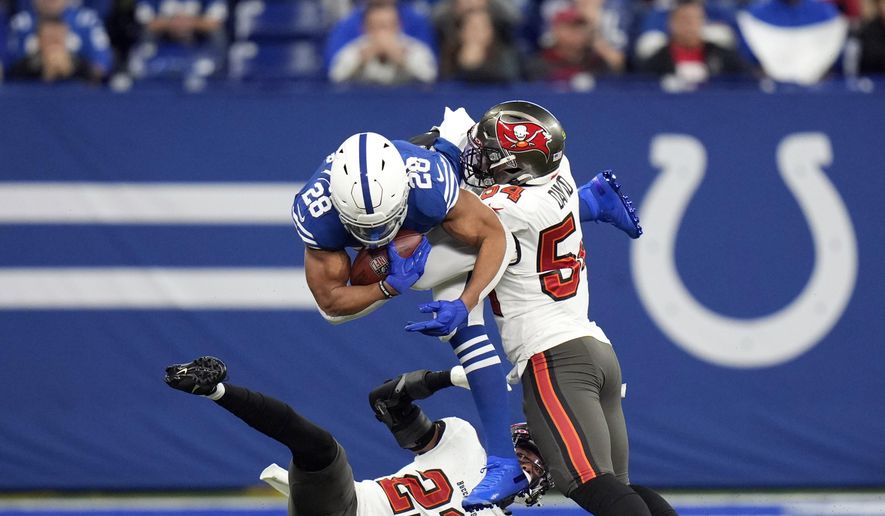 Indianapolis Colts&#39; Jonathan Taylor (28) is tackled by Tampa Bay Buccaneers&#39; Sean Murphy-Bunting (23) and Lavonte David (54) during the first half of an NFL football game, Sunday, Nov. 28, 2021, in Indianapolis. (AP Photo/AJ Mast)