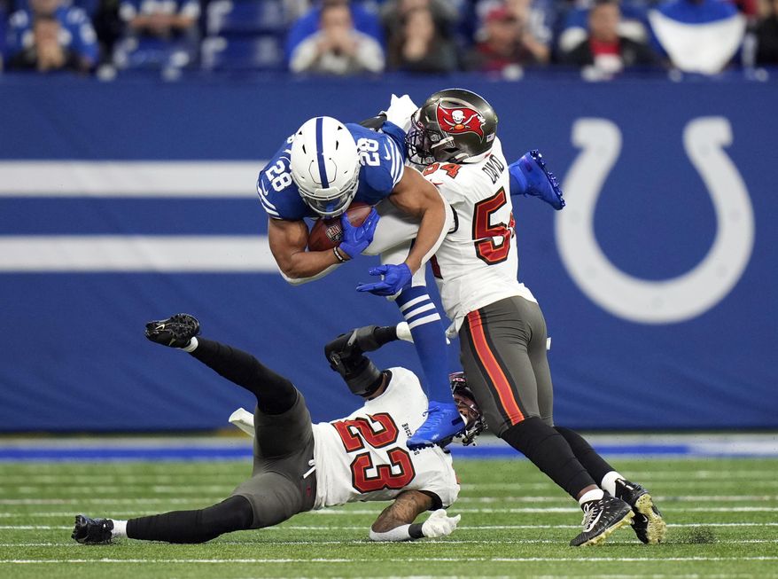 Indianapolis Colts&#x27; Jonathan Taylor (28) is tackled by Tampa Bay Buccaneers&#x27; Sean Murphy-Bunting (23) and Lavonte David (54) during the first half of an NFL football game, Sunday, Nov. 28, 2021, in Indianapolis. (AP Photo/AJ Mast)