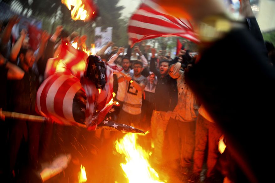 Iranian demonstrators burn representations of the U.S. flag during a protest in front of the former U.S. Embassy in response to President Donald Trump's decision Tuesday to pull out of the nuclear deal and renew sanctions, in Tehran, Iran, Wednesday, May 9, 2018. Iran and world powers resume talks in Vienna this week of Nov. 28, 2021, aimed at restoring the nuclear deal that crumbled after the U.S. pulled out three years ago. There are major doubts over whether the deal can be reinstated after years of mounting distrust. (AP Photo/Vahid Salemi) **FILE**