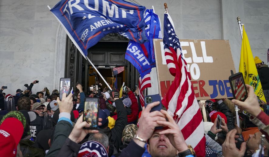 In this Jan. 6, 2021, photo, insurrections loyal to President Donald Trump riot outside the U.S. Capitol in Washington. (AP Photo/John Minchillo) **FILE**