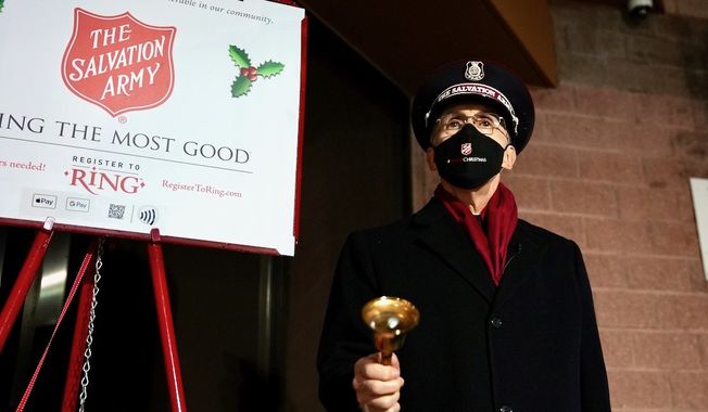 Salvation Army National Commander Commissioner Kenneth Hodder, in face mask, stands at one of the group&#x27;s Red Kettle Campaign outposts to kick off the 2021 effort. (Photo courtesy of The Salvation Army)