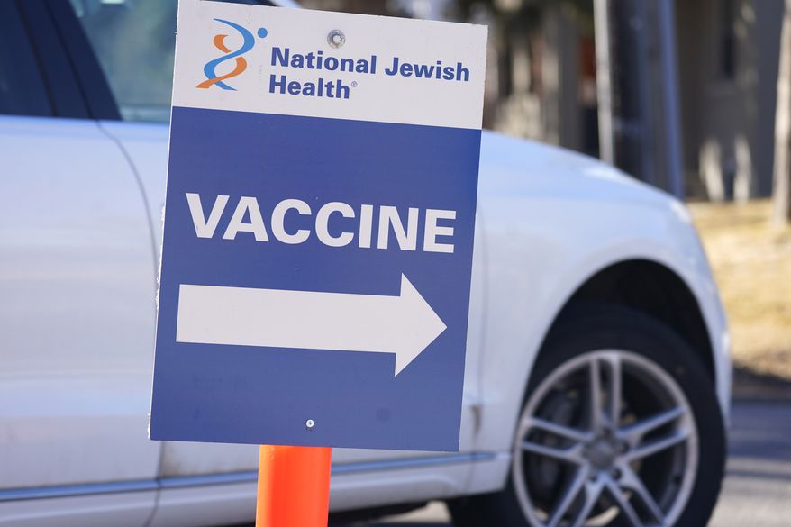 A sign directs motorists to a vaccination site at National Jewish Hospital on March 6, 2021, in east Denver. Merriam-Webster has declared vaccine its 2021 word of the year. (AP Photo/David Zalubowski, File)
