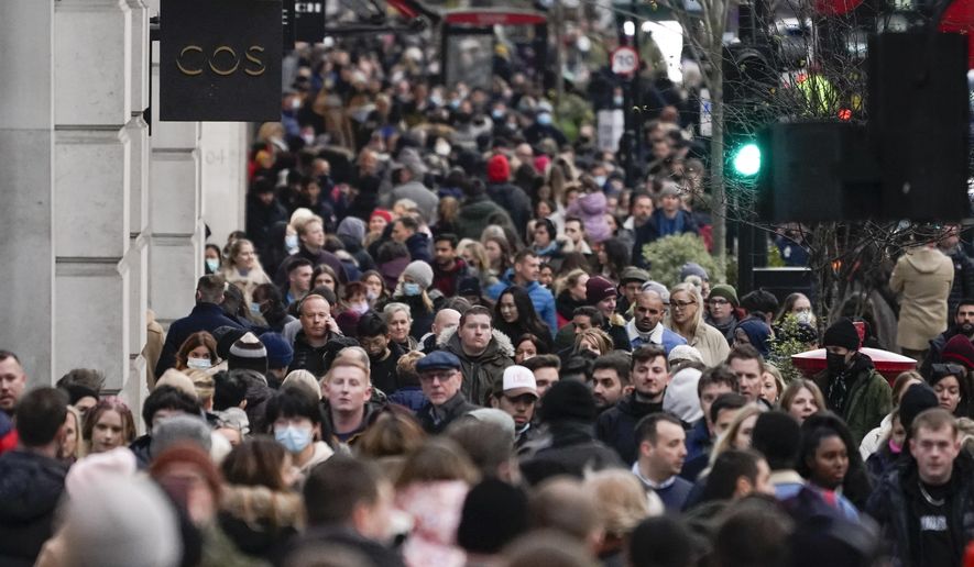 People, some wearing face masks, walk in Regent Street, in London, Sunday, Nov. 28, 2021. Britain&#39;s Prime Minister Boris Johnson said it was necessary to take &amp;quot;targeted and precautionary measures&amp;quot; after two people tested positive for the new variant in England. He also said mask-wearing in shops and on public transport will be required. (AP Photo/Alberto Pezzali)