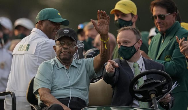 Lee Elder waves as he arrives for the ceremonial tee shots before the first round of the Masters golf tournament on Thursday, April 8, 2021, in Augusta, Ga. At far right is Phil Mickelson. Person at right in cart is unidentified. Elder broke down racial barriers as the first Black golfer to play in the Masters and paved the way for Tiger Woods and others to follow. The PGA Tour confirmed Elder’s death, which was first reported by Debert Cook of African American Golfers Digest. No cause or details were immediately available, but the tour said it spoke with Elder&#x27;s family. He was 87. (AP Photo/Charlie Riedel, File) **FILE**