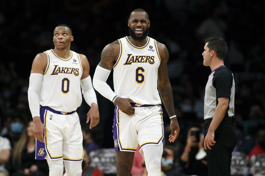 Los Angeles Lakers forward LeBron James, right, grimaces after making a basket against the Detroit Pistons, with guard Russell Westbrook, left, looking up at a video replay during the second half of an NBA basketball game Sunday, Nov. 28, 2021, in Los Angeles. (AP Photo/Alex Gallardo) ***FILE**