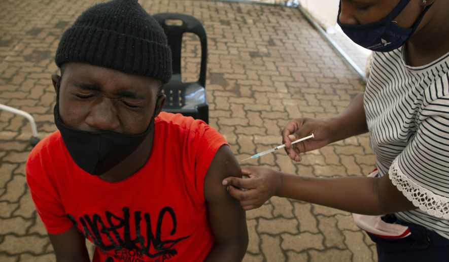 A man receives a dose of a vaccine at a COVID-19 vaccine centre, in Soweto, Monday, Nov. 29, 2021. The World Health Organization has urged countries not to impose flight bans on southern African nations due to concerns over the new omicron variant. (AP Photo/Denis Farrell)