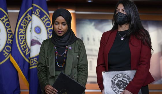 Rep. Ilhan Omar, D-Minn., left, joined by Rep. Rashida Tlaib, D-Mich., pauses before speaking to reporters in the wake of anti-Islamic comments made last week by Rep. Lauren Boebert, R-Colo., who likened Omar to a bomb-carrying terrorist, during a news conference at the Capitol in Washington, Tuesday, Nov. 30, 2021. (AP Photo/J. Scott Applewhite)