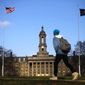 In this Friday, Nov. 11, 2011, file photo, a student walks in front of the Old Main building on the Penn State campus in State College, Pa.  (AP Photo/Matt Rourke, File)