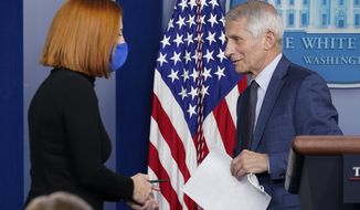 White House press secretary Jen Psaki walks to the podium as Dr. Anthony Fauci, director of the National Institute of Allergy and Infectious Diseases, departs after speaking about the COVID-19 variant named omicron during the daily briefing at the White House in Washington, Wednesday, Dec. 1, 2021. (AP Photo/Susan Walsh)