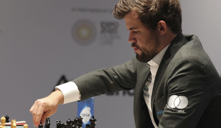 Norway&#39;s World Chess Champion Magnus Carlsen, makes a move in game five against Ian Nepomniachtchi of Russia, during the FIDE World Championship at the Dubai Expo, in Dubai, United Arab Emirates, Wednesday, Dec. 1, 2021. (AP Photo/Kamran Jebreili)