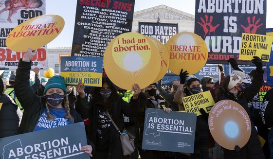 Anti-abortion and Abortion rights advocates demonstrate in front of the U.S. Supreme Court Wednesday, Dec. 1, 2021, in Washington, as the court hears arguments in a case from Mississippi, where a 2018 law would ban abortions after 15 weeks of pregnancy, well before viability. (AP Photo/Jose Luis Magana)