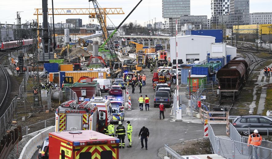 Firefighters, police officers and railway employees stand on a railway site in Munich, Germany, Wednesday, Dec. 1, 2021. Police in Germany say three people have been injured including seriously in an explosion at a construction site next to a busy railway line in Munich. (Sven Hoppe/dpa via AP)