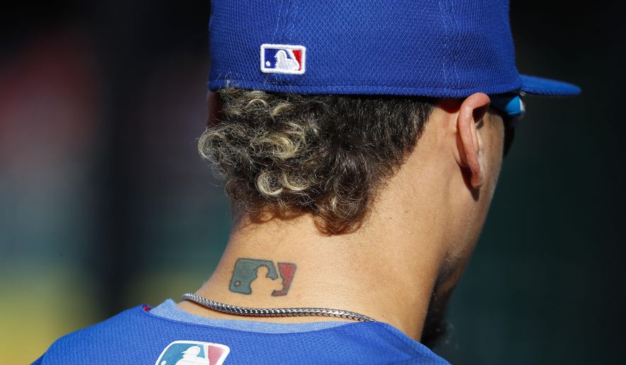 Then-Chicago Cubs&#39; Javier Baez sports an MLB logo tattoo and logos on his hat and jersey as he waits to take batting practice. (AP Photo/Pablo Martinez Monsivais, File) **FILE**