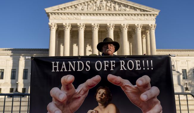 Stephen Parlato of Boulder, Colo., holds a sign that reads &amp;quot;Hands Off Roe!!!&amp;quot; outside of the Supreme Court in Washington, Tuesday, Nov. 30, 2021, as activists begin to arrive ahead of arguments on abortion at the court in Washington.(AP Photo/Andrew Harnik)