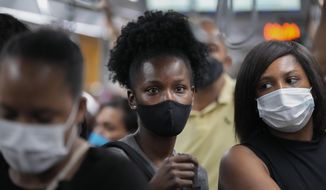 Commuters wear protective face masks as they walk through a subway station, in Sao Paulo, Brazil, Wednesday, Dec. 1, 2021, amid the COVID-19 pandemic. Brazil joined the widening circle of countries to report cases of the omicron variant. (AP Photo/Andre Penner)