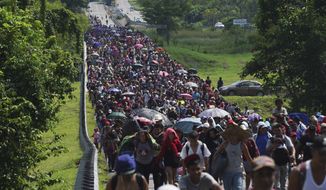 Migrants arrive in Villa Comaltitlan, Chiapas state, Mexico, on Oct. 27, 2021, as they continue their journey through Mexico to the U.S. border. The Biden administration struck agreement with Mexico to reinstate a Trump-era border policy next week that forces asylum-seekers to wait in Mexico for hearings in U.S. immigration court, U.S. officials said Thursday. (AP Photo/Marco Ugarte, File)