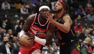 Washington Wizards&#39; Montrezl Harrell, left, is fouled by Cleveland Cavaliers&#39; Lamar Stevens (8) during the first half of an NBA basketball game, Friday, Dec. 3, 2021, in Washington. (AP Photo/Luis M. Alvarez)