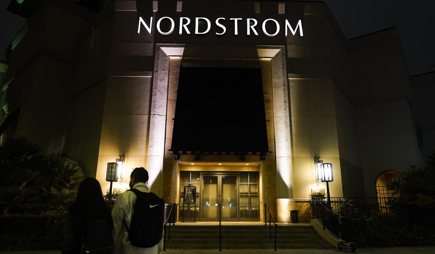 Two pedestrians walk near a closed street entrance to a Nordstrom department store at the Grove mall in Los Angeles, Thursday, Dec. 2, 2021, where a recent smash-and-grab robbery took place. Prosecutors and retailers are pushing back on assertions by California’s governor and attorney general that they have enough tools to combat shoplifting. California Retailers Association president Rachel Michelin says shoplifting has been a growing problem.   (AP Photo/Jae C. Hong)