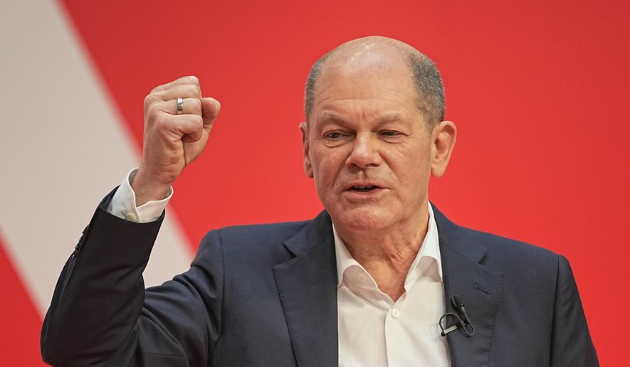 Olaf Scholz, SPD Chancellor-designate speaks at the SPD party conference at Willy Brandt House in Berlin, Germany, Saturday, Dec.4, 2021. Delegates vote on a coalition agreement with the FDP and Bündnis90/Die Grünen to form a new federal government. (Michael Kappeler/dpa via AP)