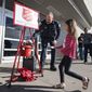 Odessa Police Department Chief Michael Gerke helps Brooklyn Silvas, 6, drop a five-dollar bill in his kettle as he rings the bell to help raise money for the Salvation Army outside of a Walmart Super Center Saturday, Dec. 4, 2021, in Odessa, Texas. (Eli Hartman/Odessa American via AP)