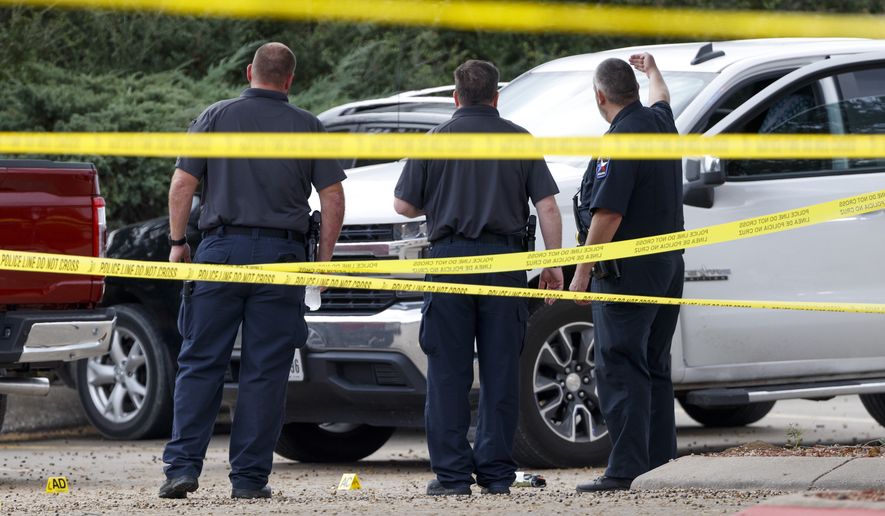 Mesquite police officers investigate the site of an officer-involved shooting, Dec. 3, 2021, in Mesquite, Texas. Police have released the name of the officer who was fatally shot while responding to a disturbance call outside a suburban Dallas supermarket. Mesquite police said Saturday that Officer Richard Houston was killed Friday. Police said a prayer vigil will be held for him Sunday, Dec. 5, 2021 in front of the police department. (Elias Valverde II/The Dallas Morning News via AP)
