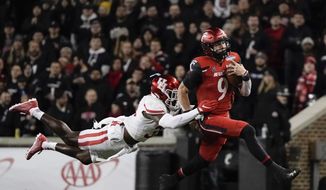 Cincinnati quarterback Desmond Ridder (9) is tackled by Houston&#39;s Gervarrius Owens during the second half of the American Athletic Conference championship NCAA college football game Saturday, Dec. 4, 2021, in Cincinnati. (AP Photo/Jeff Dean) **FILE**