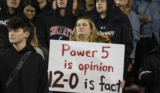 A fan holds a sign during the second half of the American Athletic Conference championship NCAA college football game between Cincinnati and Houston Saturday, Dec. 4, 2021, in Cincinnati. (AP Photo/Jeff Dean)