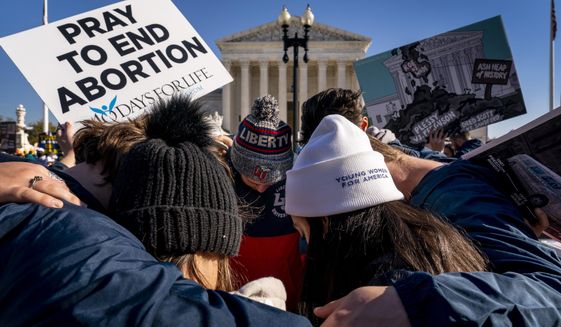 FILE - A group of anti-abortion protesters pray together in front of the U.S. Supreme Court, Dec. 1, 2021, in Washington, as the court hears arguments in a case from Mississippi, where a 2018 law would ban abortions after 15 weeks of pregnancy, well before viability. As the Supreme Court court weighs the future of the landmark 1973 Roe v. Wade decision, a resurgent anti-abortion movement is looking to press its advantage in state-by-state battles while abortion-rights supporters prepare to play defense. (AP Photo/Andrew Harnik, File)