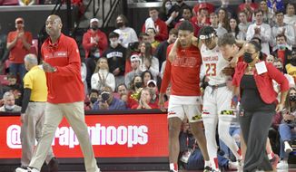 Maryland interim head coach Danny Manning, left, walks on the court as Ian Martinez (23) is helped off the court after an injury during an NCAA college basketball game against Northwestern in College Park, Md., Sunday, Dec. 5, 2021. (Amy Davis/The Baltimore Sun via AP) **FILE**