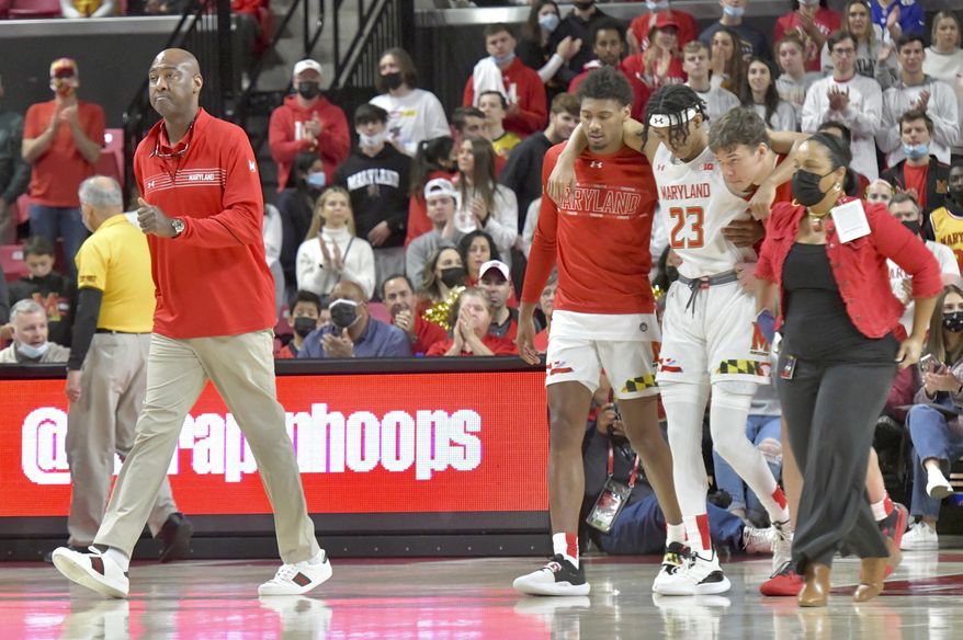Maryland interim head coach Danny Manning, left, walks on the court as Ian Martinez (23) is helped off the court after an injury during an NCAA college basketball game against Northwestern in College Park, Md., Sunday, Dec. 5, 2021. (Amy Davis/The Baltimore Sun via AP) **FILE**