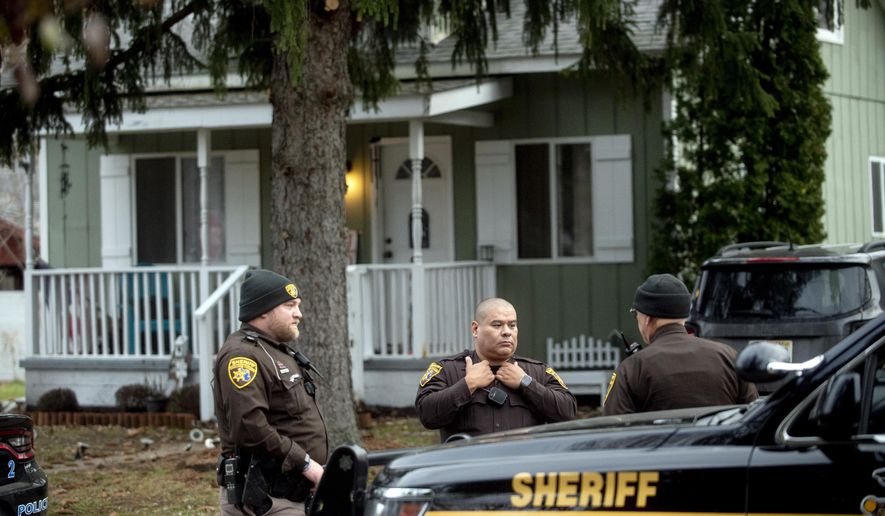 FILE - Three Oakland County Sheriff&#39;s deputies survey the grounds outside of the Crumbley residence while seeking James and Jennifer Crumbley, parents of Oxford High School shooter Ethan Crumbley, Dec. 3, 2021, in Oxford, Mich. A Detroit-area artist whose studio was where the parents of the Oxford High School student charged in a deadly shooting were found by police is cooperating with authorities and didn’t know the couple had stayed overnight, his attorney said Sunday, Dec, 5, 2021. (Jake May/The Flint Journal via AP)